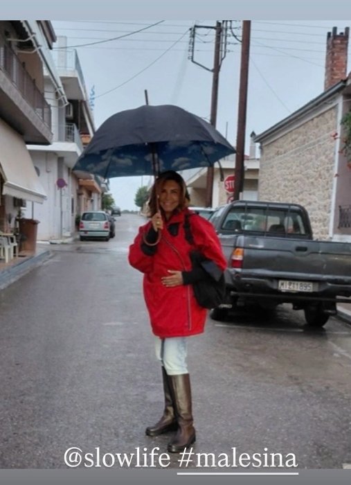 Μιμή Ντενίση: Η chic εμφάνισή της εν μέσω βροχής - Με γαλότσες, τζιν και oversized κόκκινο τζάκετ